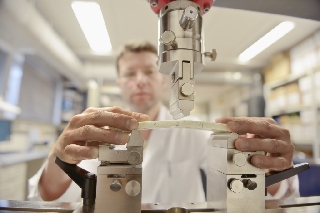 man in white lab coat performing test on sample