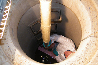 man in manhole installing short liner