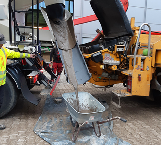 flowable backfill flowing from mixing truck into wheelbarrow