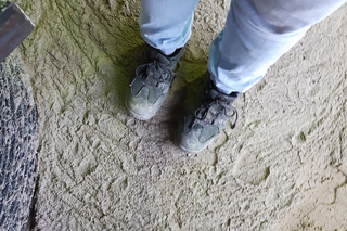 person with work shoes standing on hardened flowable backfill